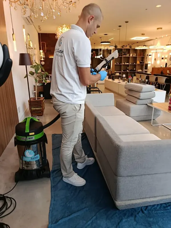 Evandro, da LimpeSanté, higienizando um sofá com extratora profissional